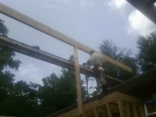 Carpenter setting a ridge beam over a new addition frame — Ice Dam Removal by Roofing Brothers in Randall