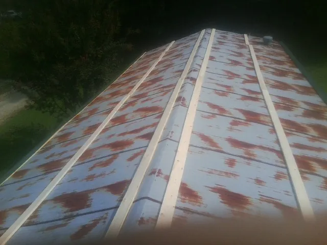 Rusted metal roof panels with new wood purlins before replacement — Storm Damage Roof Repair in Randall by Roofing Brothers