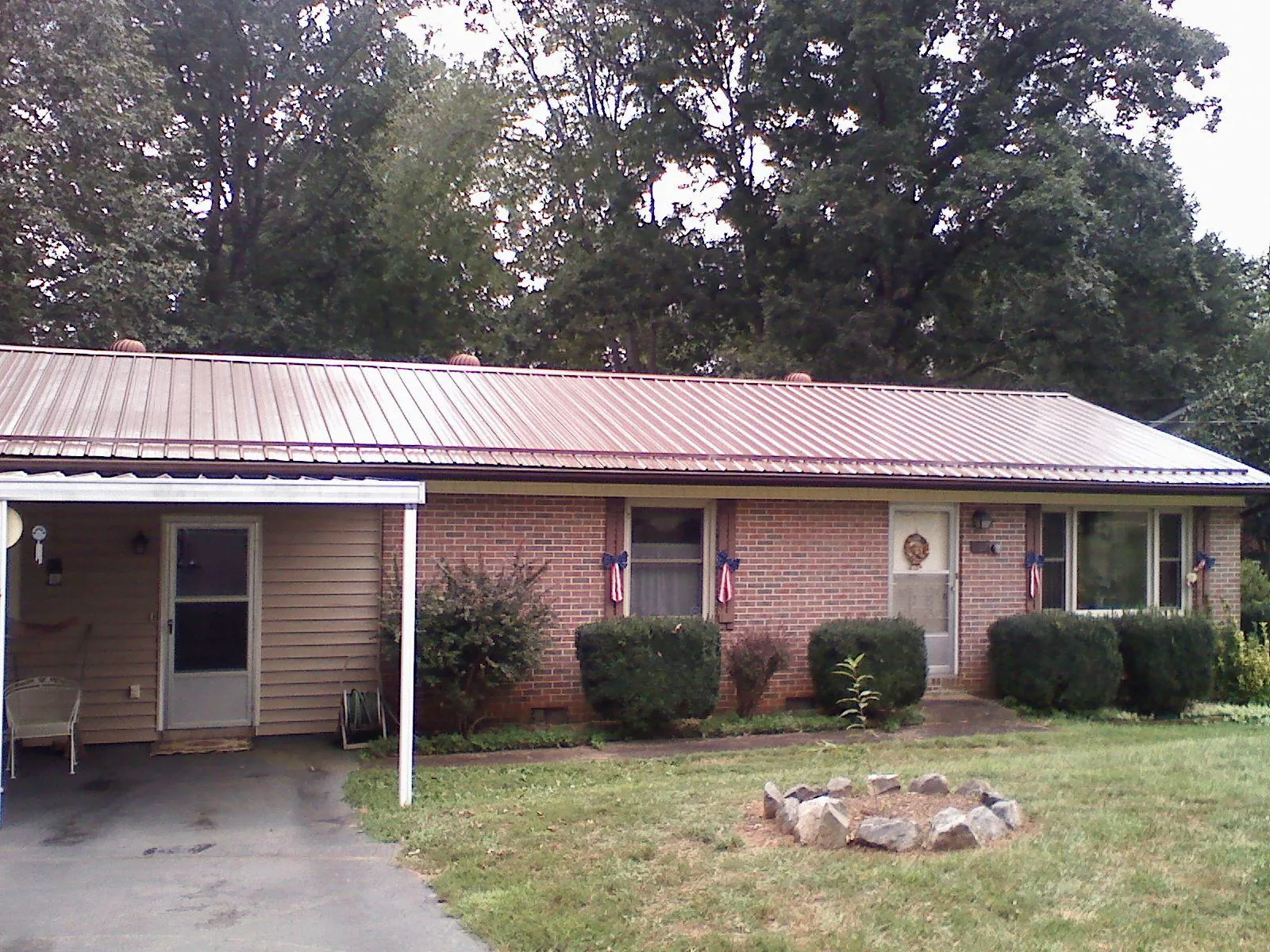 Bronze metal roof and carport on a brick ranch home — Roof Repair work by our crew in Randall